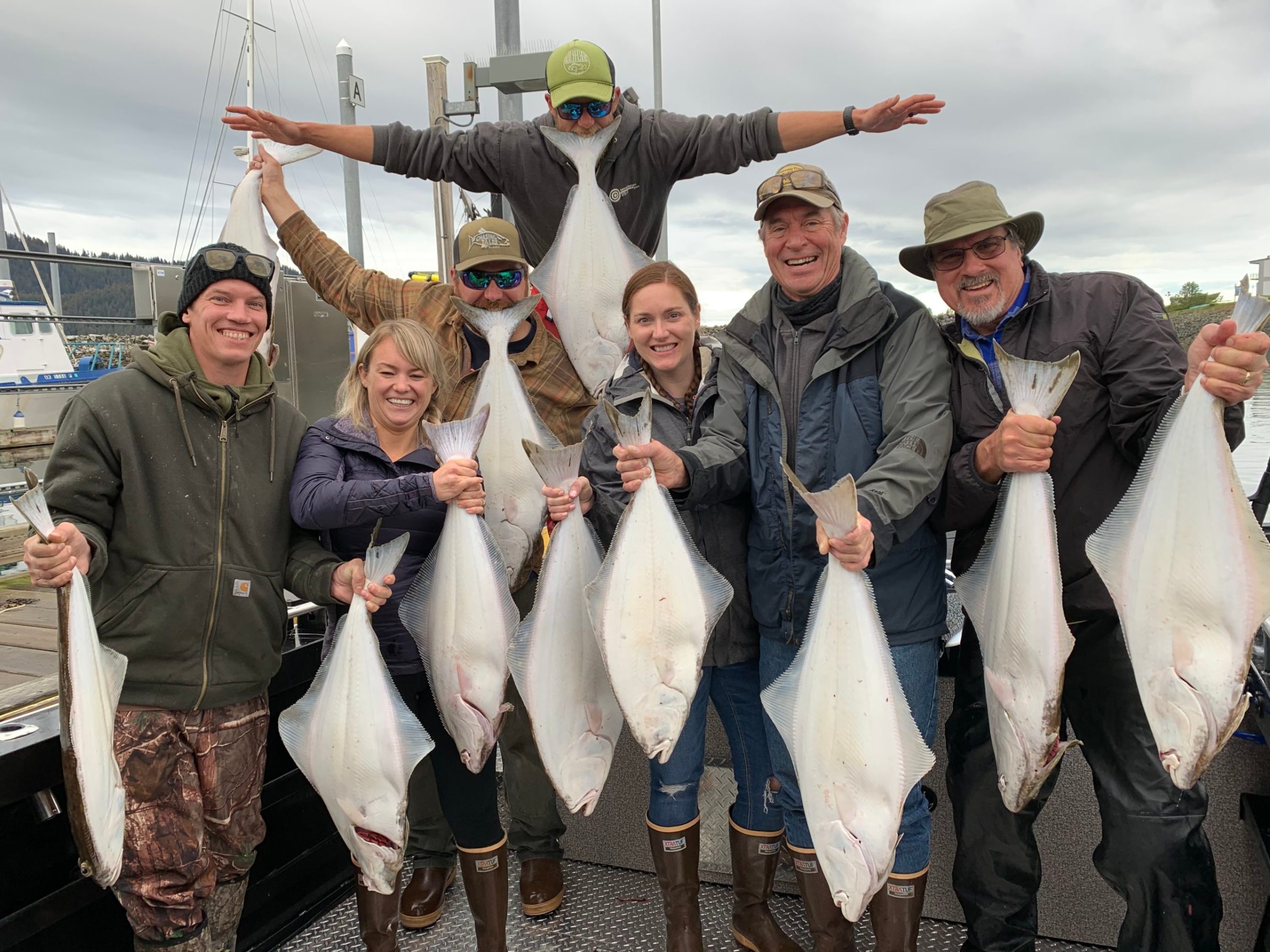 a group of people standing next to a person holding a fish